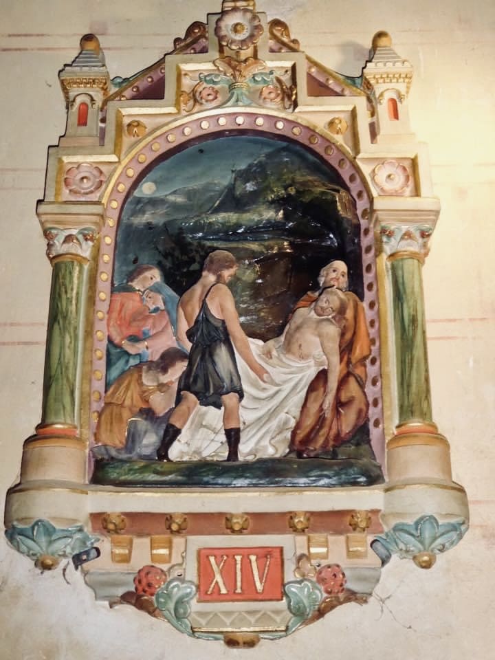 Station of the cross at the church of rennes-le-château showing jesus being either removed or placed in a tomb