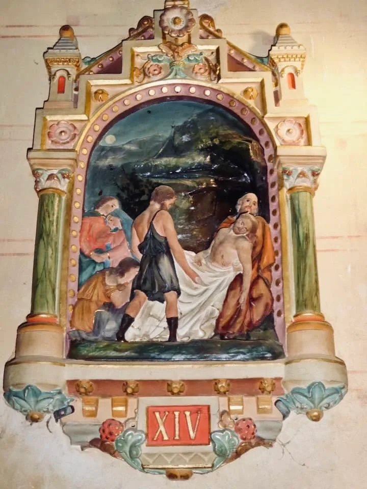 Station of the cross at the church of rennes-le-château showing jesus being either removed or placed in a tomb